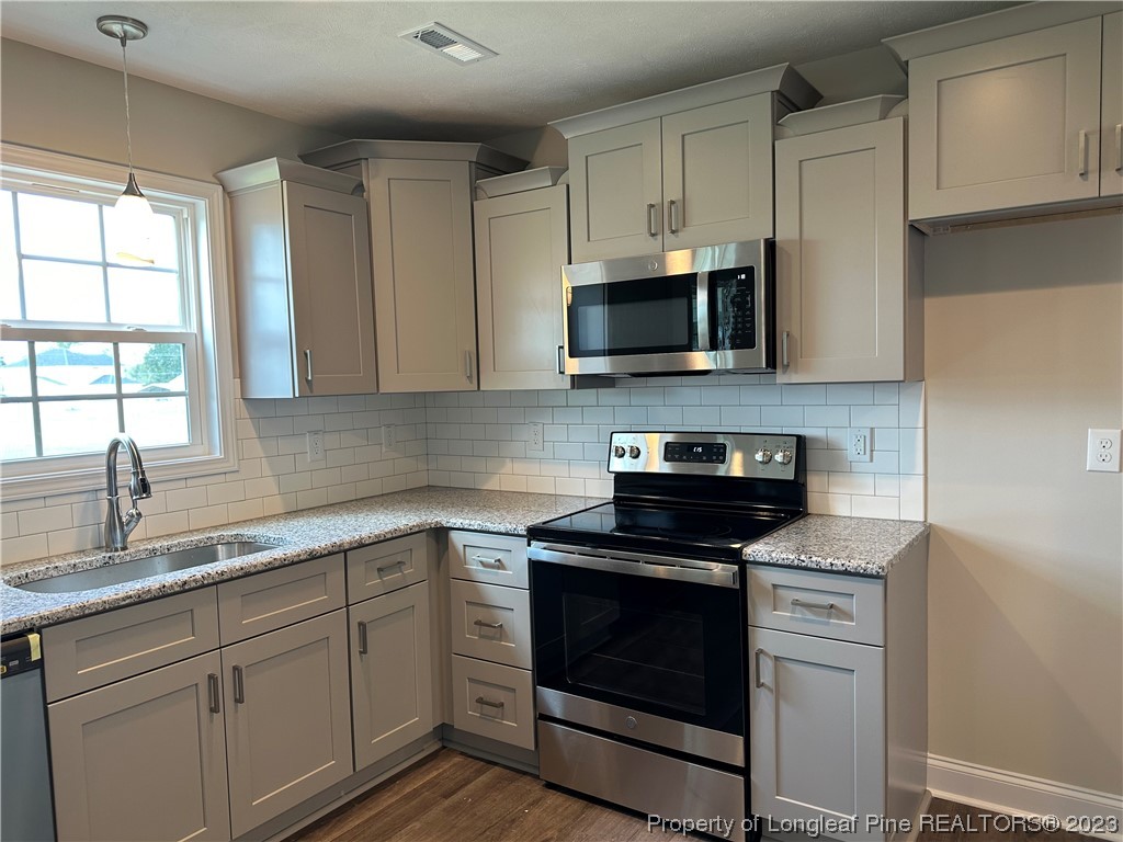 2526 Sand Hill Road Fayetteville, NC 28306 - Photo 8 of 40 a kitchen with cabinets stainless steel appliances a sink and a window