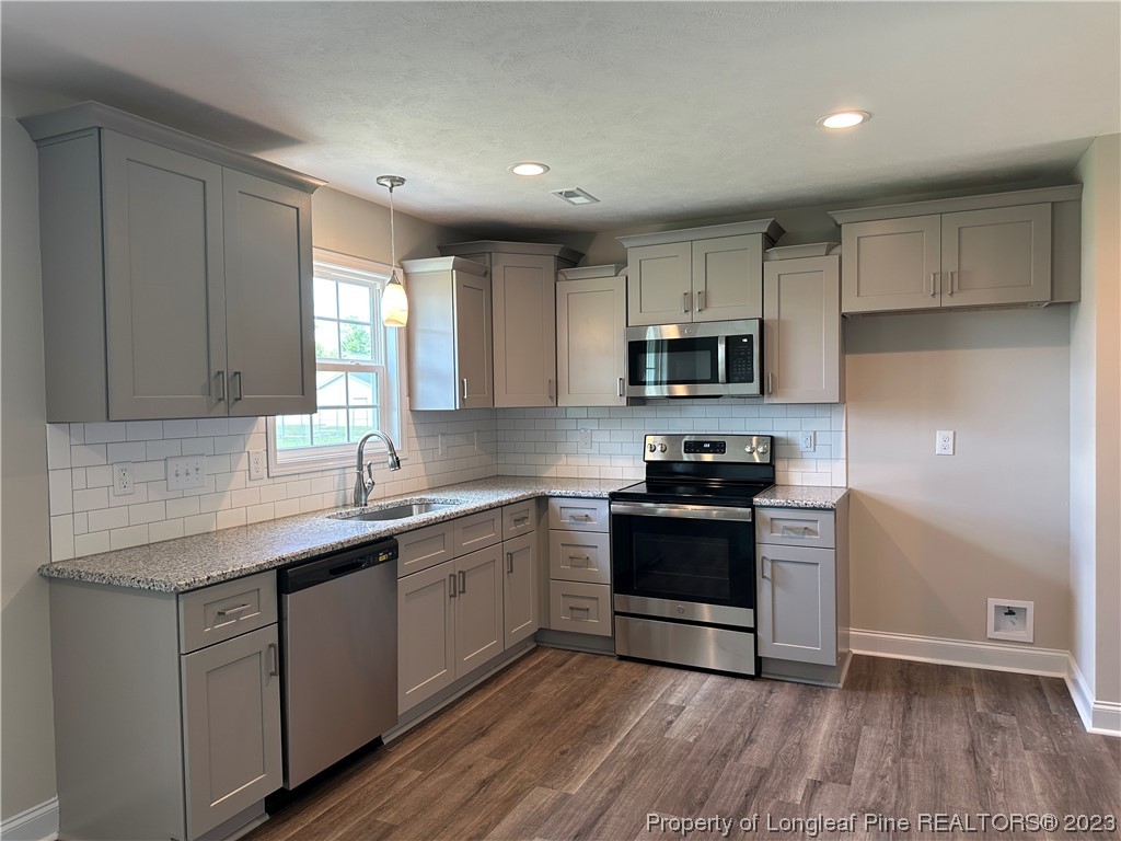 2526 Sand Hill Road Fayetteville, NC 28306 - Photo 9 of 40 a kitchen with stainless steel appliances granite countertop a stove a sink and a microwave