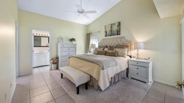 a spacious bedroom with a bed and a lamp