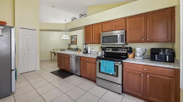 a kitchen with stainless steel appliances granite countertop a stove a sink and a refrigerator