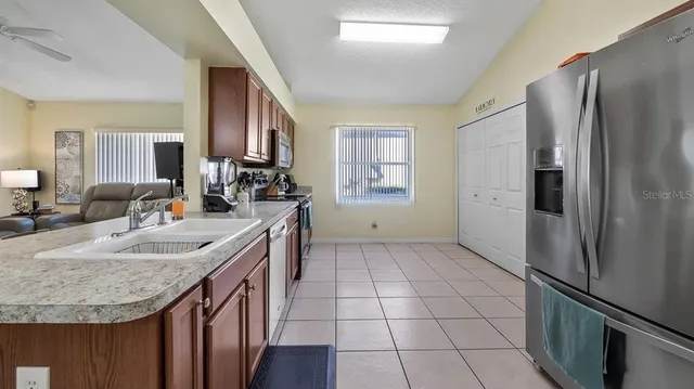 a kitchen with granite countertop a sink stove and refrigerator