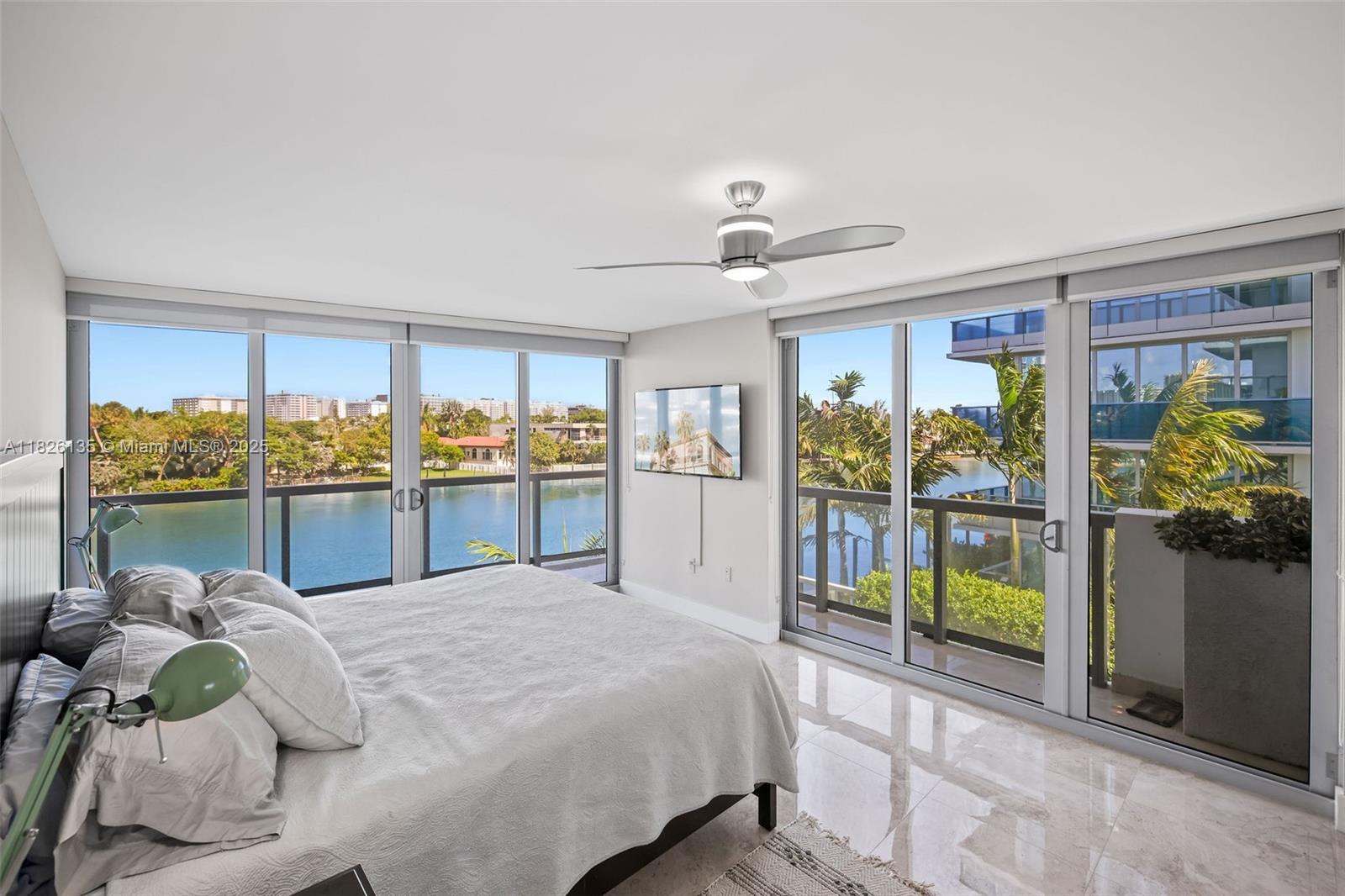9261 East Bay Harbor Drive, Unit 404 Bay Harbor Islands, FL 33154 - Photo 24 of 49 a bed sitting in a bedroom next to a large window