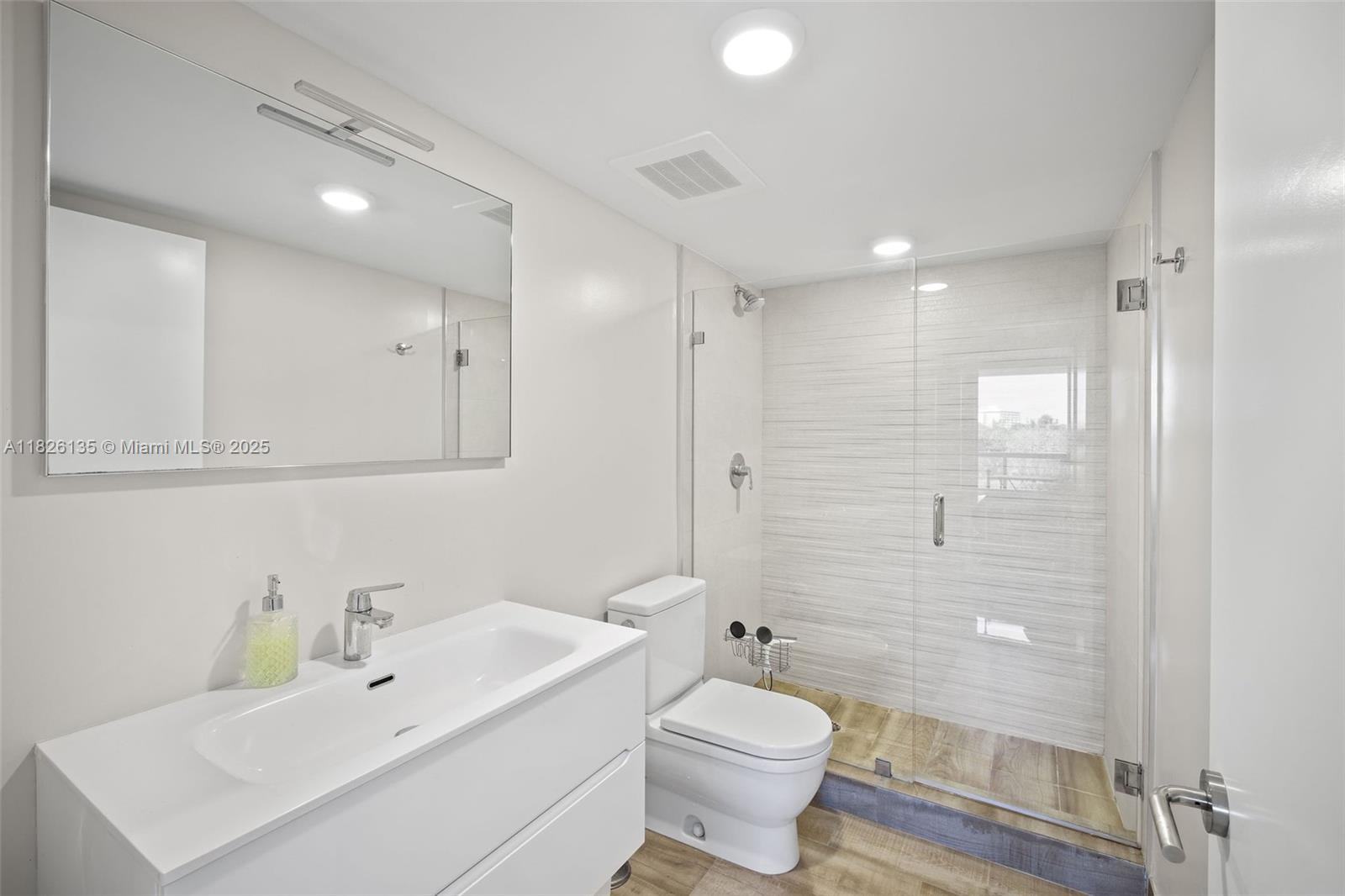 9261 East Bay Harbor Drive, Unit 404 Bay Harbor Islands, FL 33154 - Photo 36 of 49 a bathroom with a sink toilet a mirror and shower