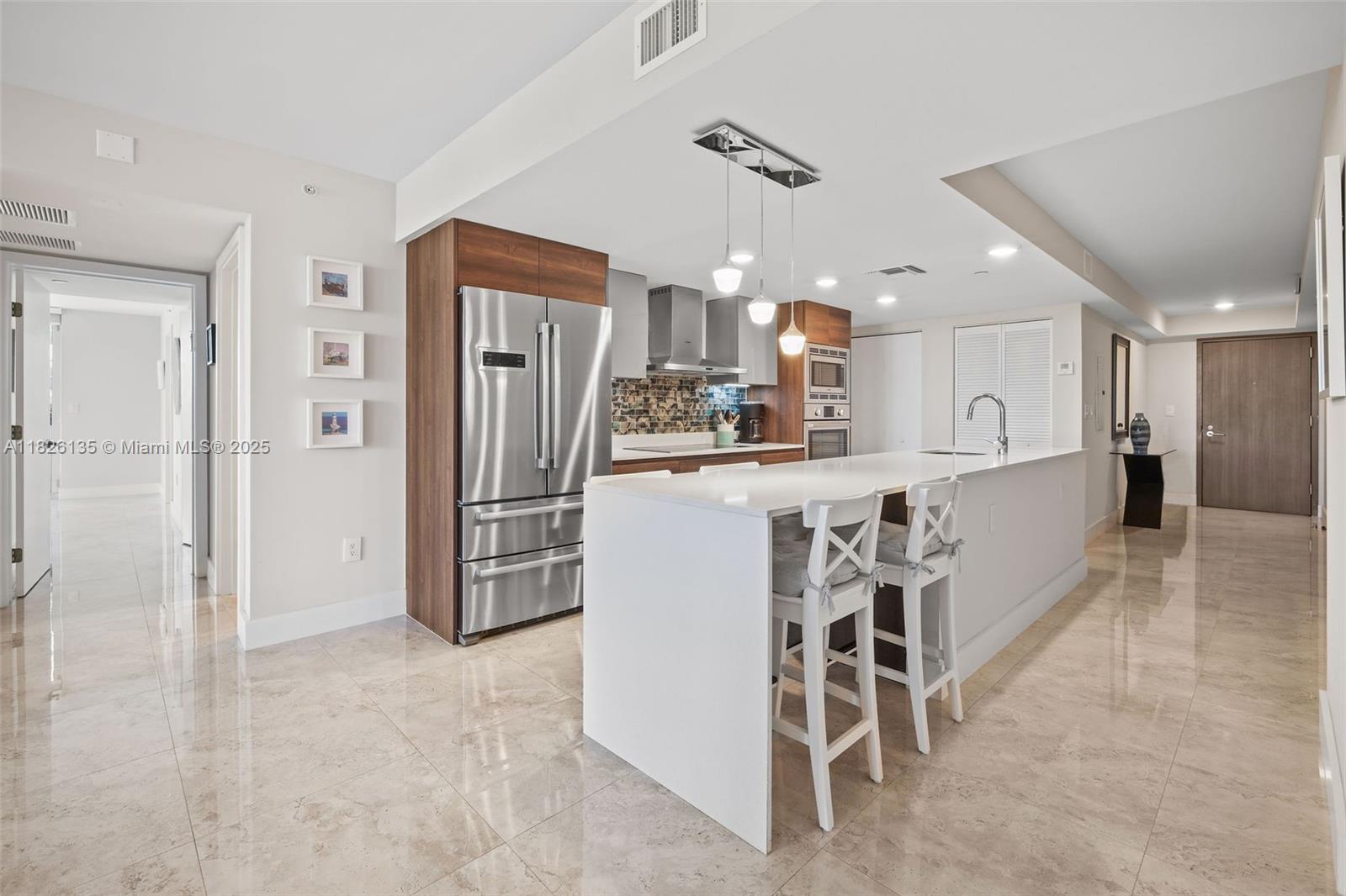 9261 East Bay Harbor Drive, Unit 404 Bay Harbor Islands, FL 33154 - Photo 6 of 49 a kitchen with stainless steel appliances granite countertop a refrigerator and a sink