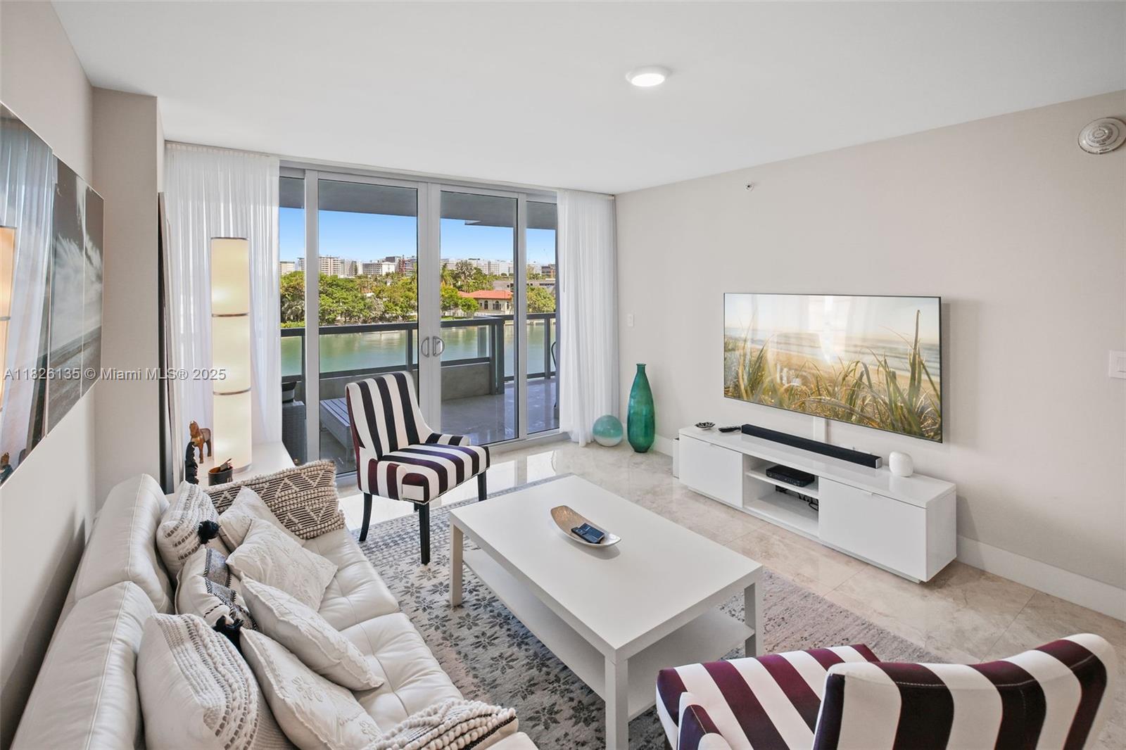 9261 East Bay Harbor Drive, Unit 404 Bay Harbor Islands, FL 33154 - Photo 10 of 49 a living room with furniture a flat screen tv and a large window