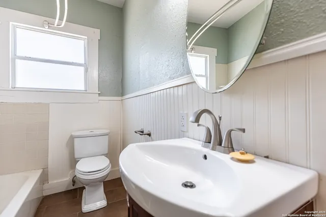 a bathroom with a toilet sink and mirror