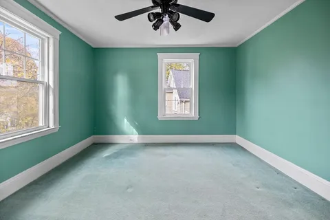 an empty room with a window and a ceiling fan