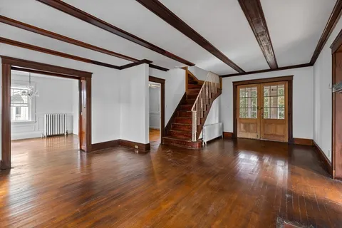 a view of a hallway with wooden floor and stairs
