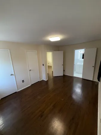 an empty room with wooden floor and white walls
