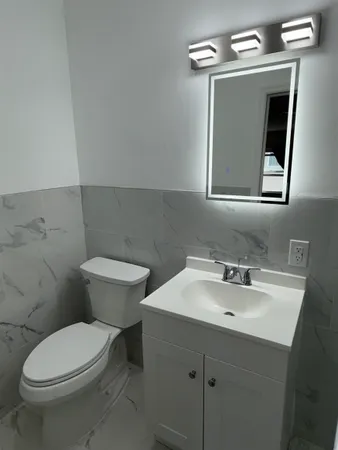a bathroom with a toilet sink and mirror
