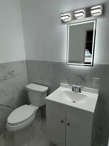 a bathroom with a toilet sink and mirror