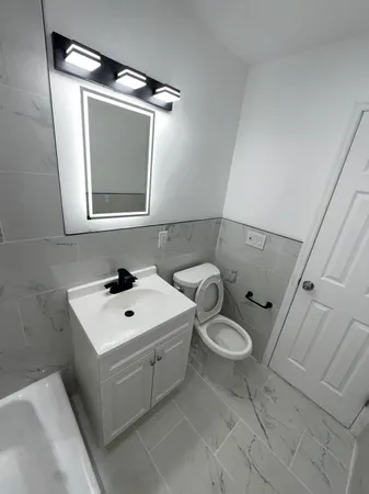 a bathroom with a toilet sink and mirror