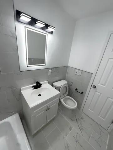 a bathroom with a toilet sink and mirror