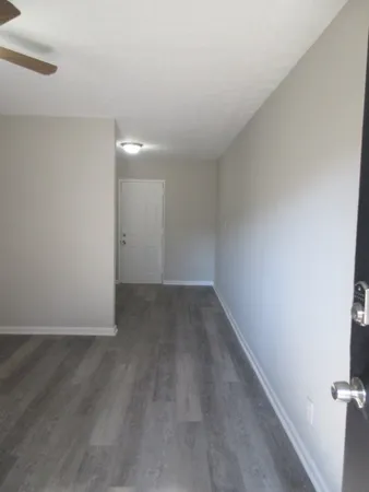 a view of an empty room with wooden floor