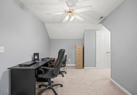 a view of a workspace with furniture and a window