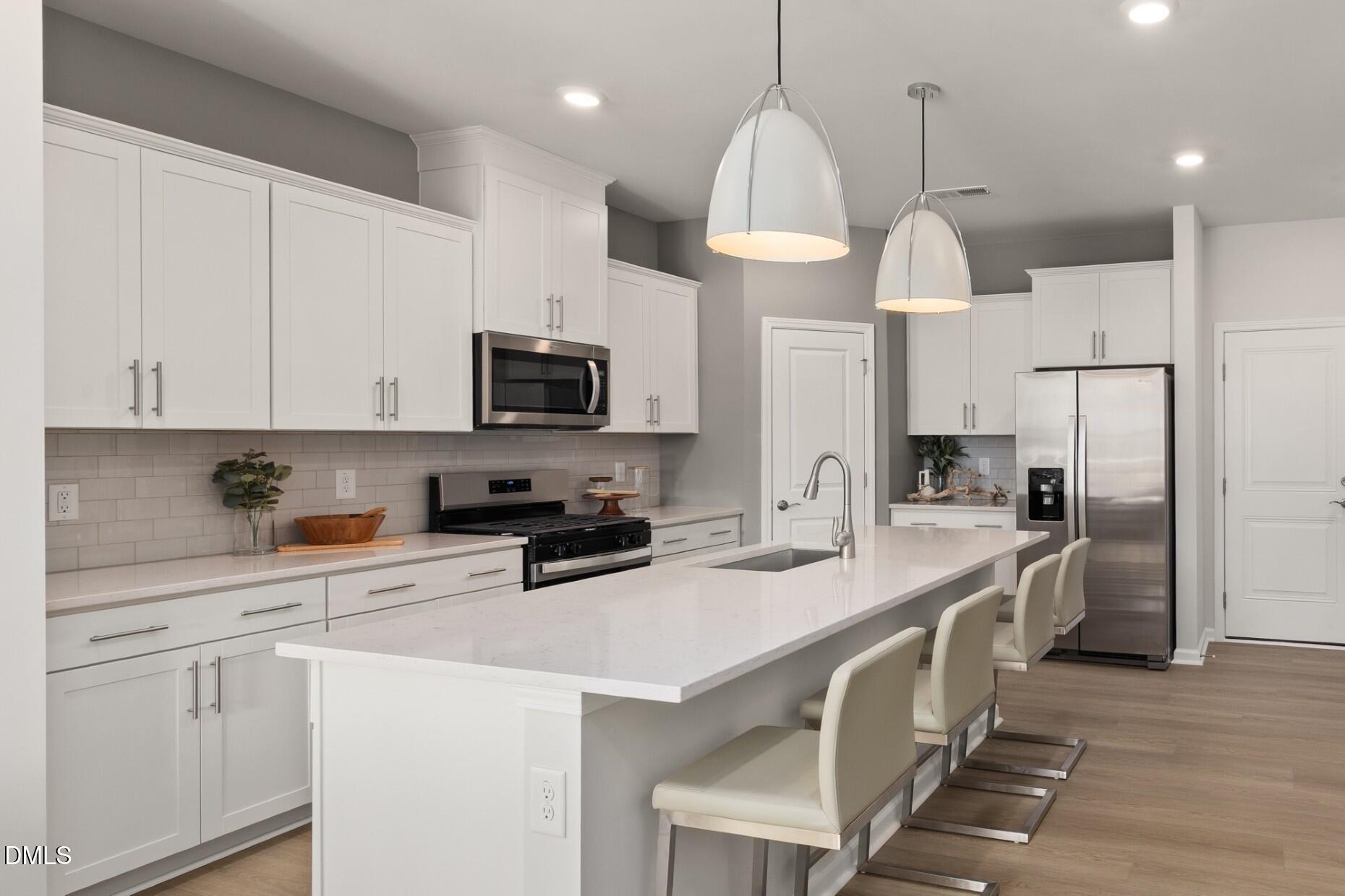 2901 Denson Road Fuquay-Varina, NC 27526 - Photo 6 of 31 a kitchen with stainless steel appliances a sink a stove a refrigerator a center island and cabinets