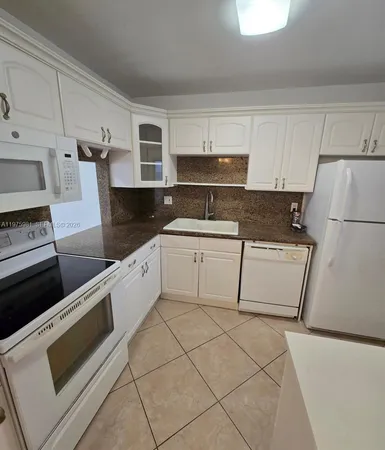 a kitchen with a white cabinets and white appliances