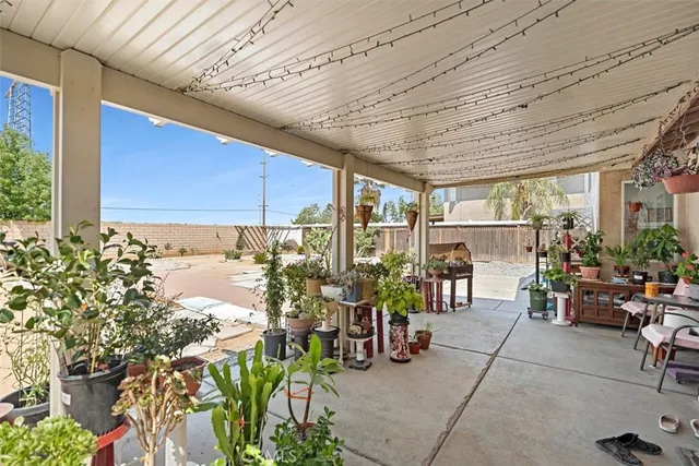 a view of a patio with table and chairs potted plants