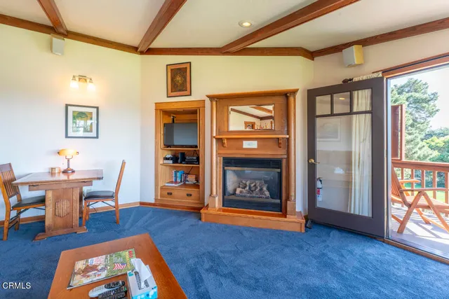 a open kitchen with stainless steel appliances granite countertop a stove top oven a sink a dining table and chairs with wooden floor