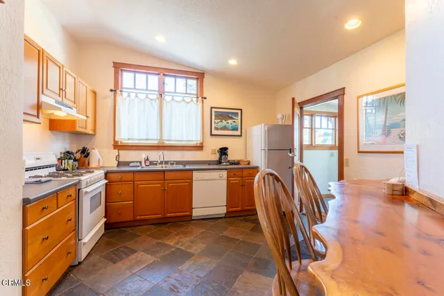 a kitchen with stainless steel appliances granite countertop wooden floors and white cabinets