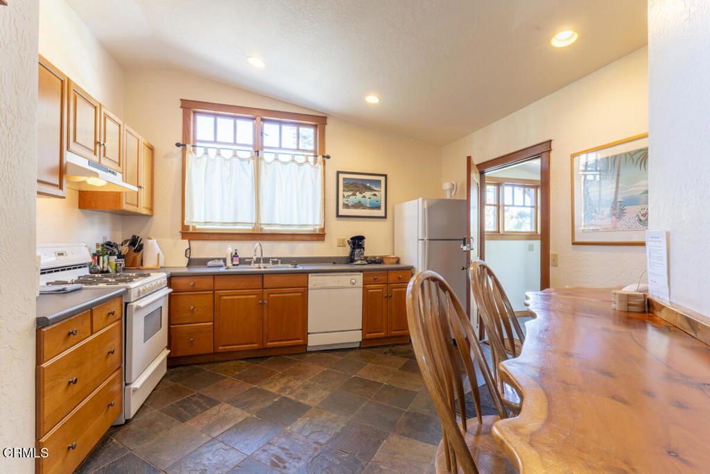 44920 Little Lake Road Mendocino, CA 95460 - Photo 23 of 62 a open kitchen with stainless steel appliances granite countertop a stove top oven a sink a dining table and chairs with wooden floor