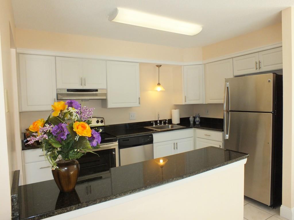 93 Kent Court, Unit 93 Meriden, CT 06450 - Photo 2 of 27 a kitchen with stainless steel appliances granite countertop a refrigerator sink stove and white cabinets