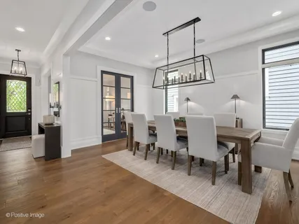 a view of a dining room with furniture a chandelier and wooden floor