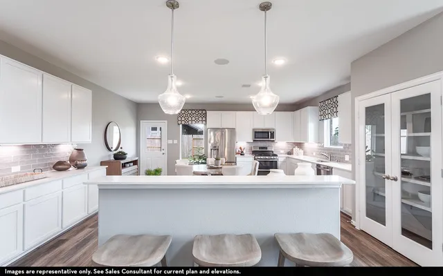a kitchen with kitchen island granite countertop a sink cabinets and stainless steel appliances