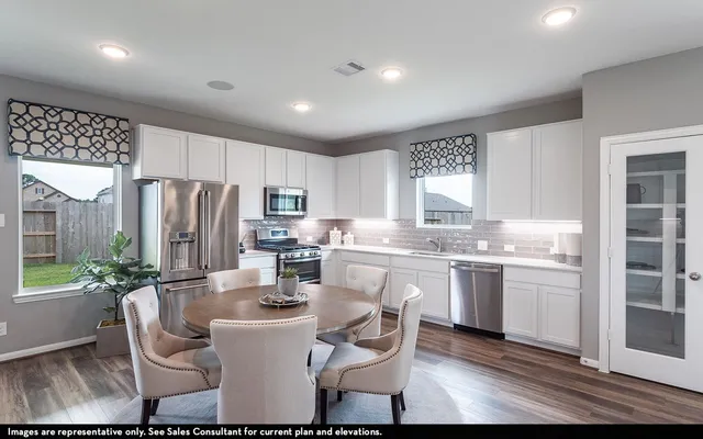 a kitchen with refrigerator and chairs