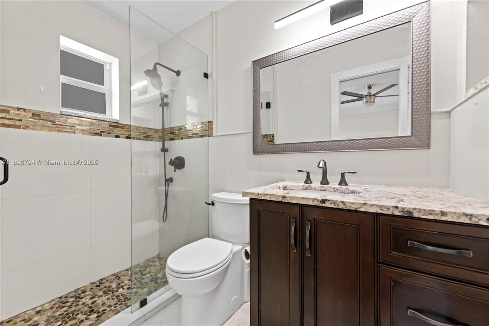 8440 Southwest 201st Street Cutler Bay, FL 33189 - Photo 19 of 31 a bathroom with a granite countertop sink mirror and toilet