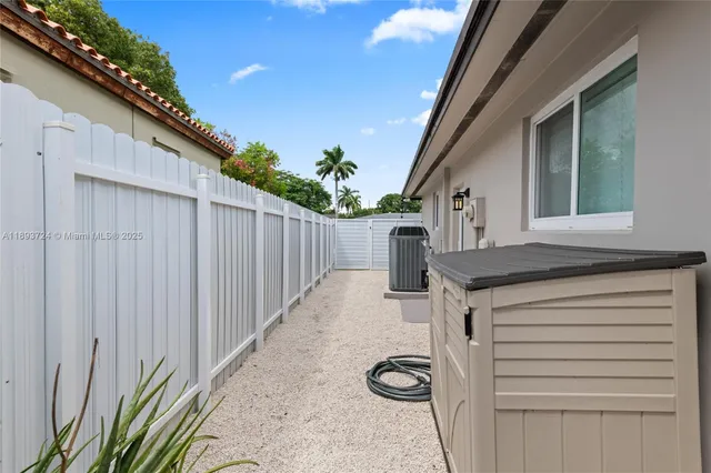 a view of a backyard with wooden fence and a stairs