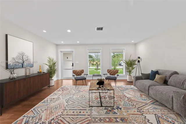 a living room with furniture and wooden floor