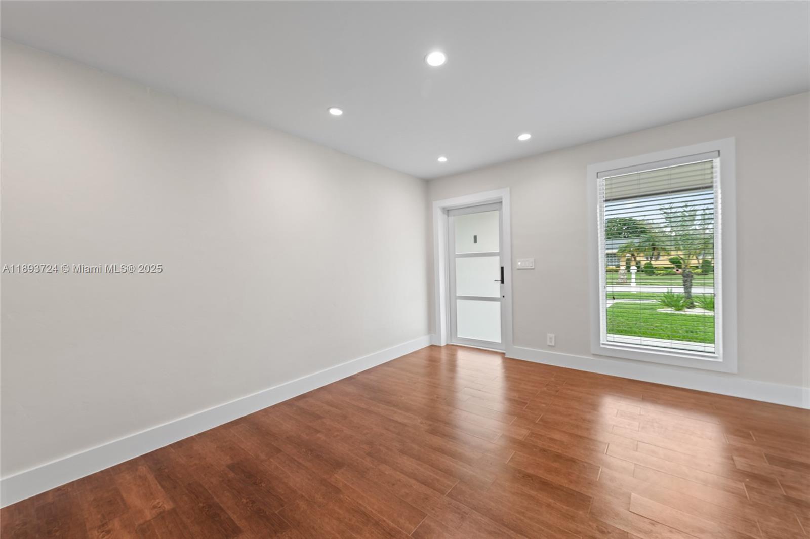 8440 Southwest 201st Street Cutler Bay, FL 33189 - Photo 7 of 31 a view of an empty room with wooden floor and windows