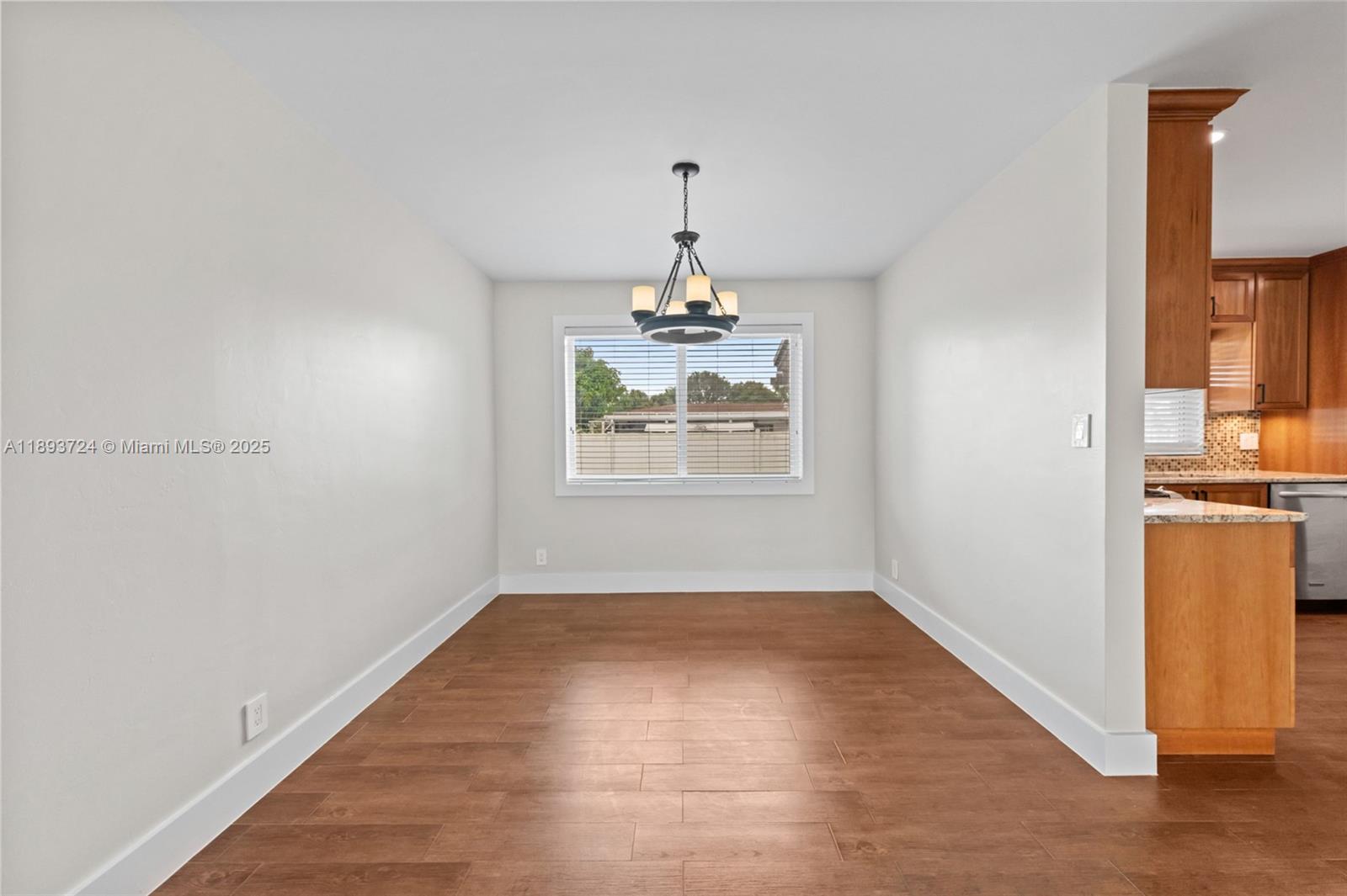 8440 Southwest 201st Street Cutler Bay, FL 33189 - Photo 9 of 31 an empty room with windows and chandelier