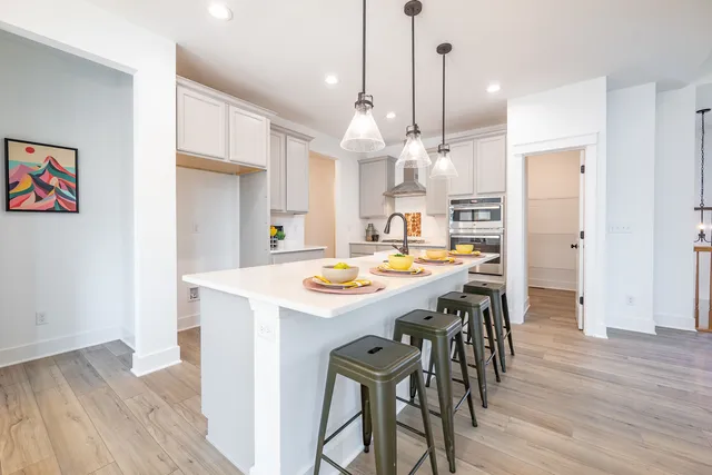 a kitchen with stainless steel appliances kitchen island a island in the center and wooden floors