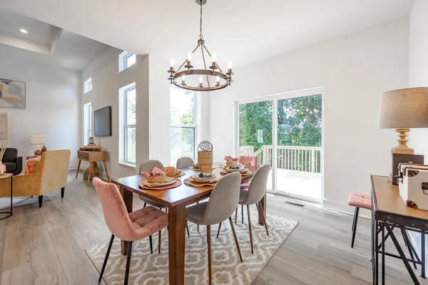 a dining room with furniture a chandelier and wooden floor