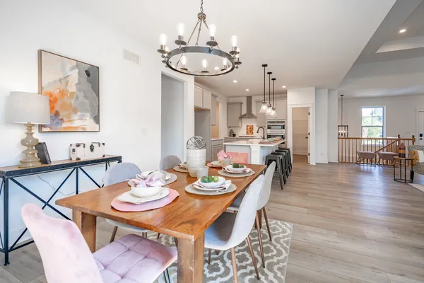 a view of a dining room with furniture a chandelier and wooden floor
