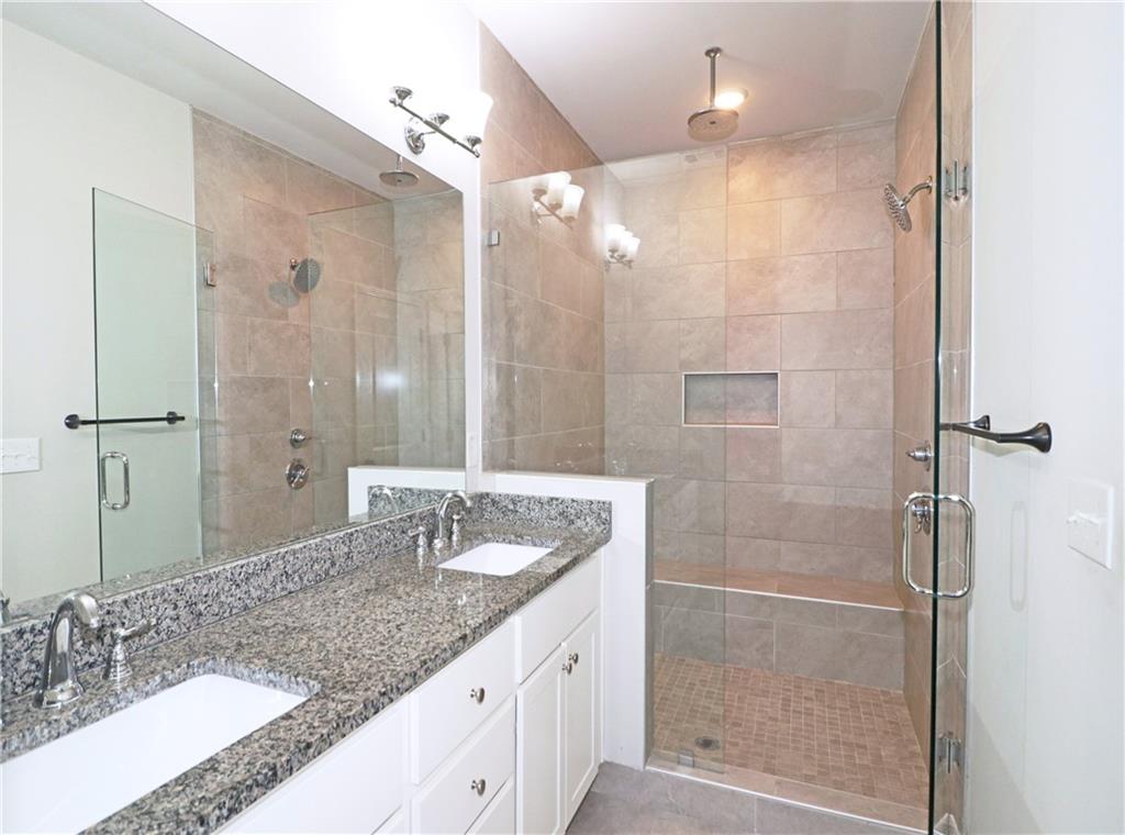 1212 Stone Castle Circle Smyrna, GA 30080 - Photo 23 of 39 a bathroom with a granite countertop shower sink and mirror