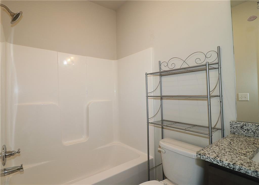 1212 Stone Castle Circle Smyrna, GA 30080 - Photo 29 of 39 a bathroom with a granite countertop sink a toilet and bathtub