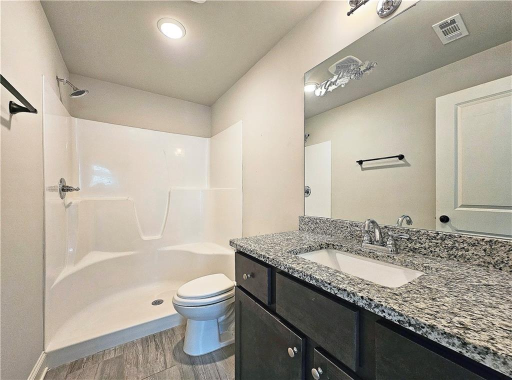 1212 Stone Castle Circle Smyrna, GA 30080 - Photo 31 of 39 a bathroom with a granite countertop sink toilet and shower