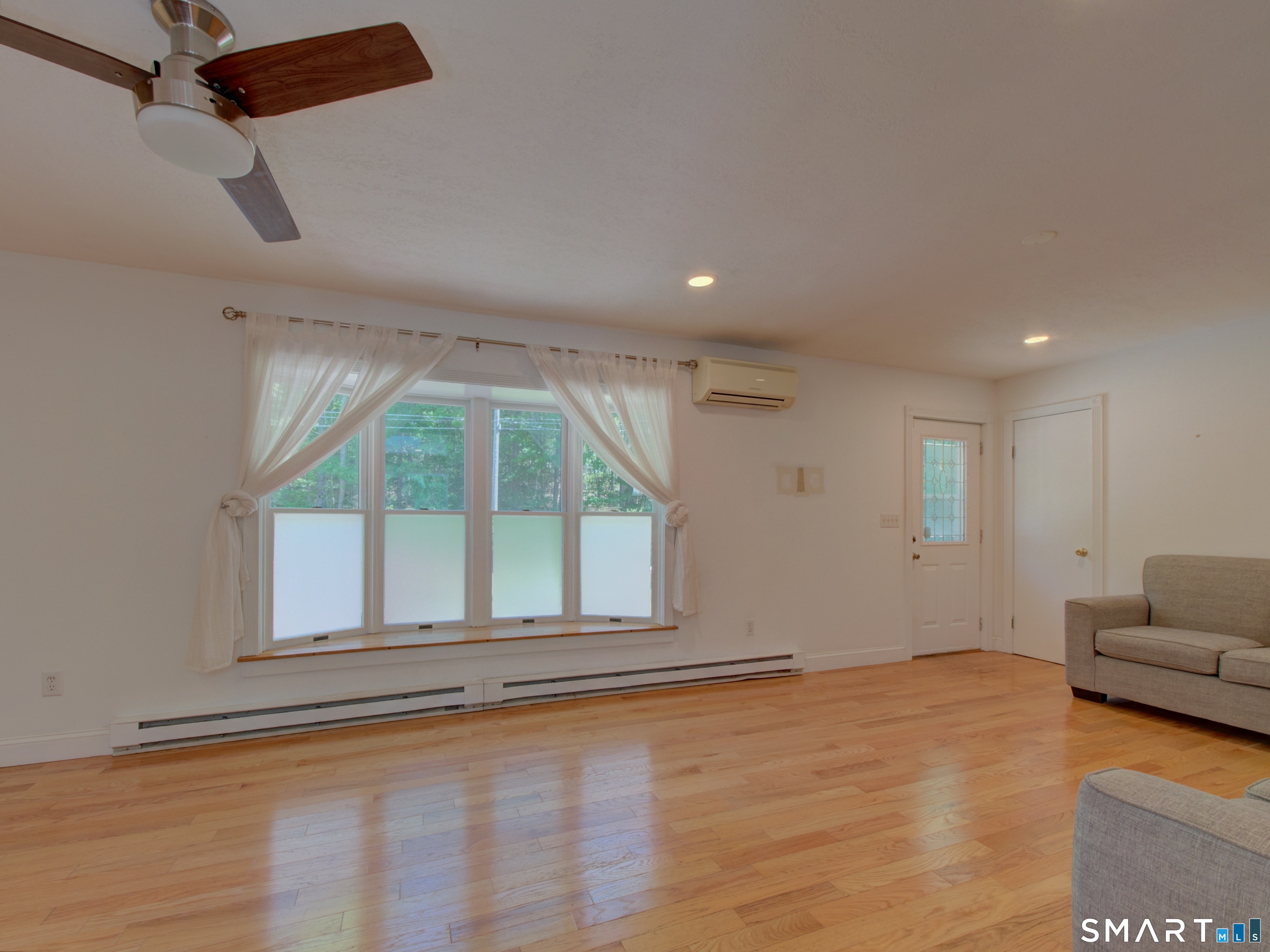 311 Sandy Hollow Road Groton, CT 06355 - Photo 5 of 26 an empty room with windows and ceiling fan