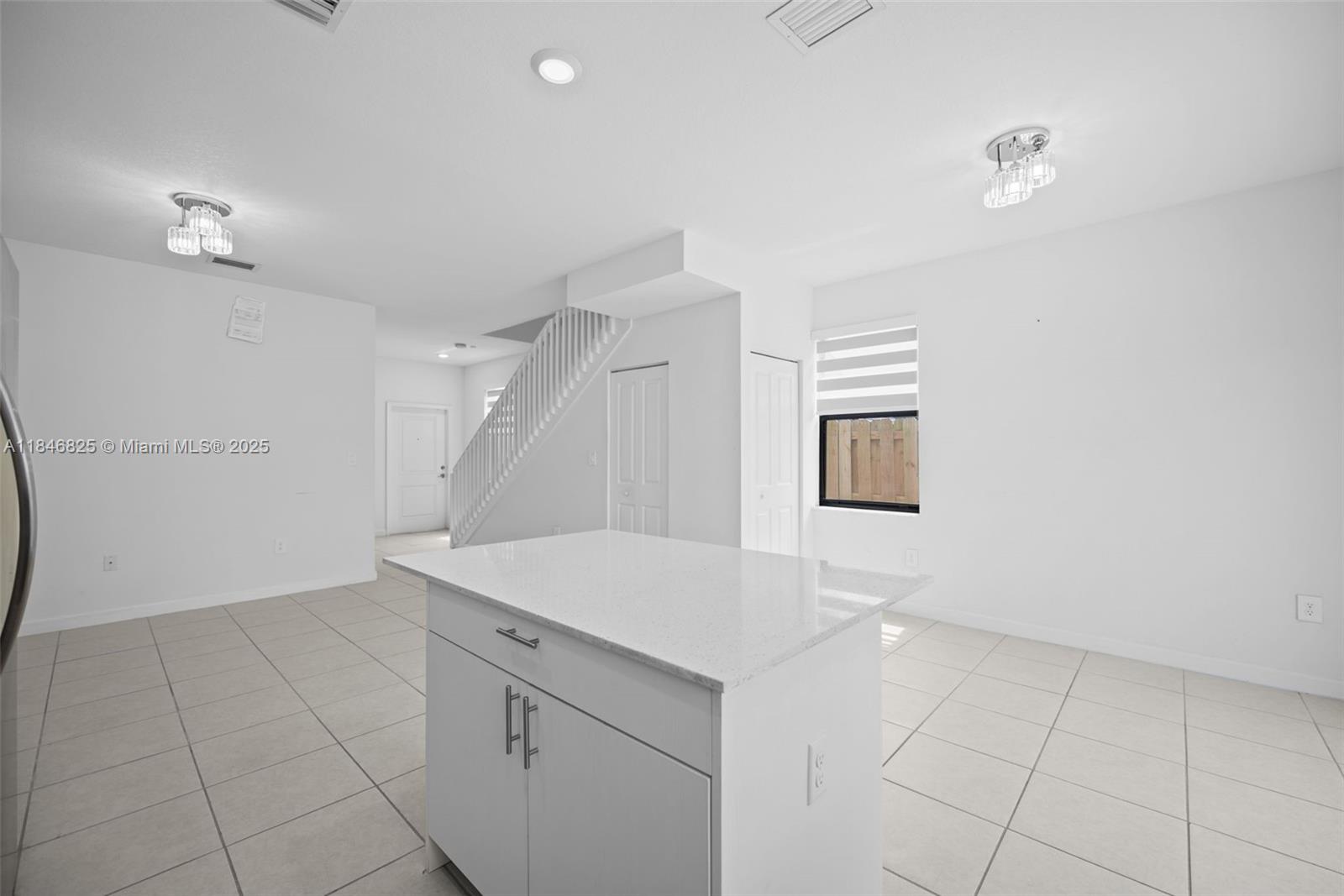 12965 Southwest 233rd Terrace Homestead, FL 33032 - Photo 11 of 25 a view of a kitchen with white cabinets and wooden floor