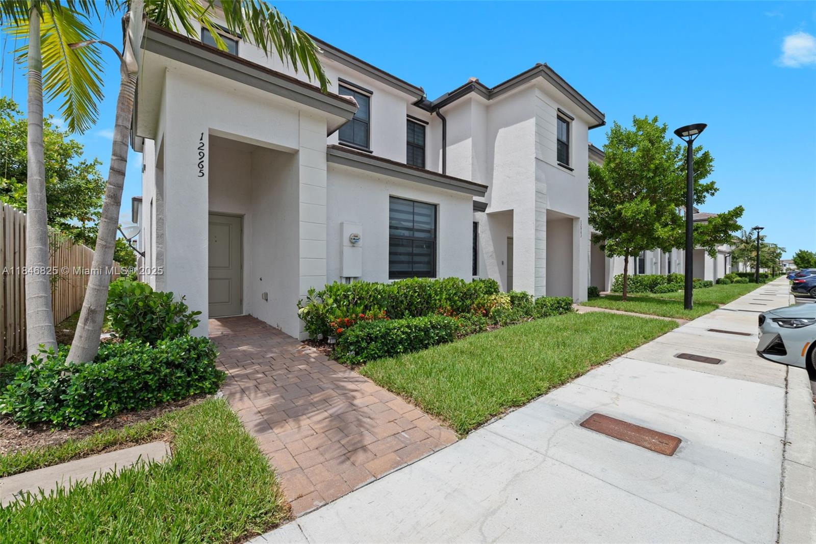 12965 Southwest 233rd Terrace Homestead, FL 33032 - Photo 3 of 25 a front view of a house with a yard and trees