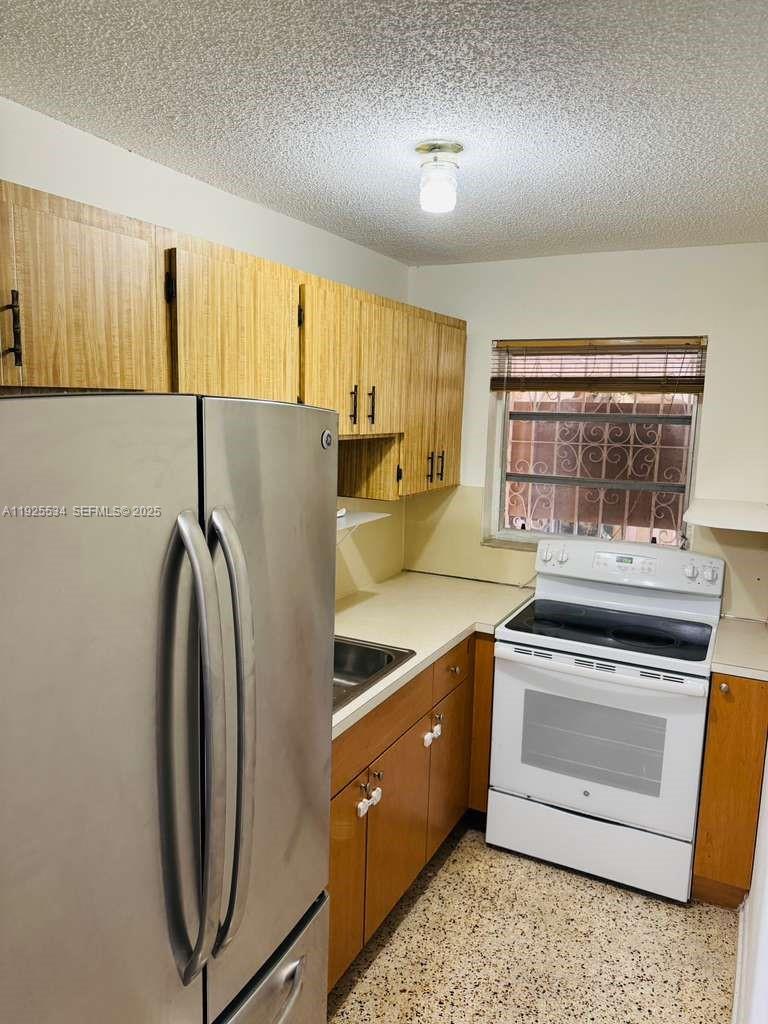 751 Southeast 6th Place, Unit 2 Hialeah, FL 33010 - Photo 4 of 8 a kitchen with stainless steel appliances granite countertop a refrigerator a stove a sink and a microwave