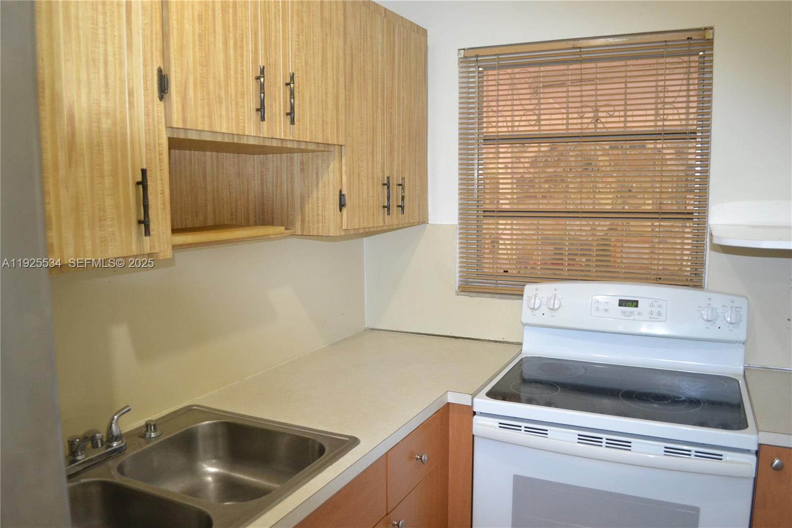 751 Southeast 6th Place, Unit 2 Hialeah, FL 33010 - Photo 5 of 8 a kitchen with a stove and a sink
