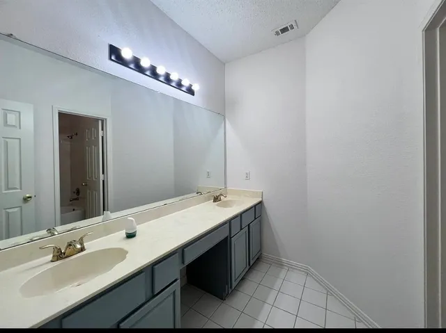 a bathroom with a double vanity sink and a mirror