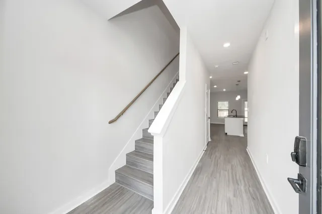a dining room with wooden floor a chandelier a wooden table and chairs
