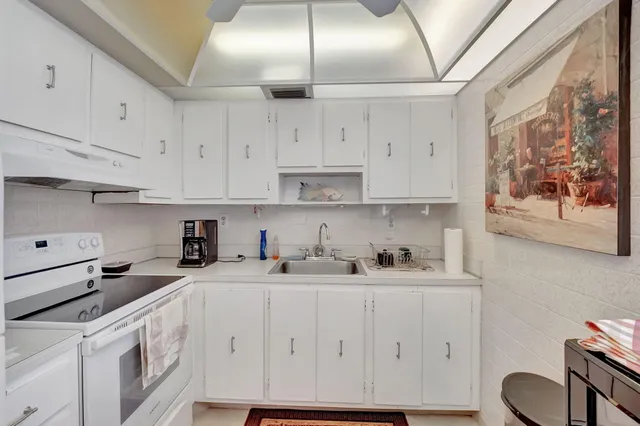 a kitchen with stainless steel appliances granite countertop a sink a stove and cabinets