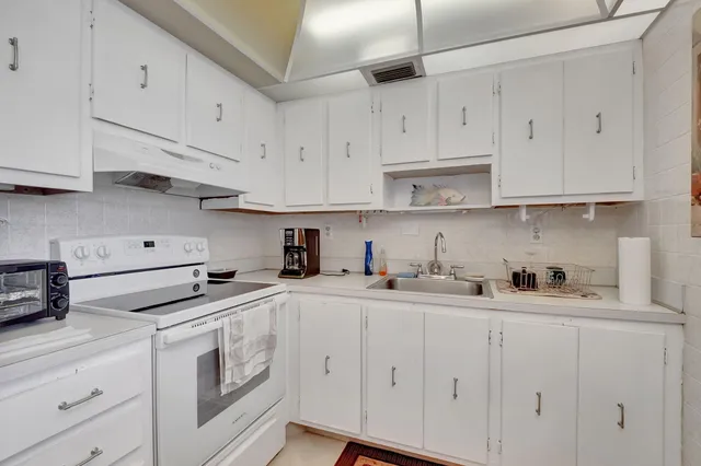 a kitchen with white cabinets and white appliances