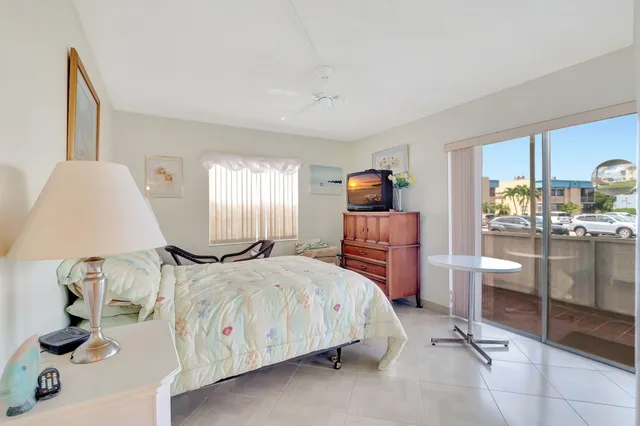 a bedroom with a bed and large windows